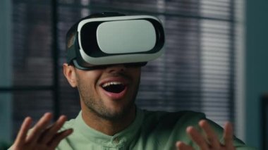 Surprised african american man in VR glasses in 3D digital metaverse world play online male gamer enjoying video game using virtual reality headset satisfied with modern innovative technology concept