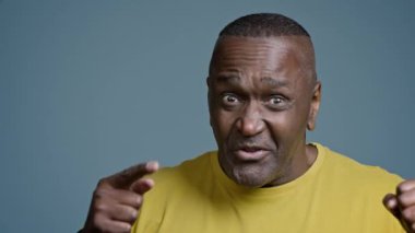 Close-up mature african american man sportsman coach in studio blue background talking to webcam athletic male professional online trainer mentor instructor instruct cheers up sport motivation concept