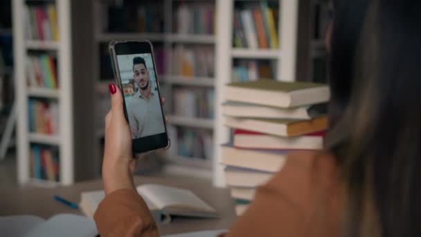 Üniversite Kütüphanesinde Oturan Genç Kız Öğrencinin Görüntüsü Cep Telefonuyla Iletişim — Stok video