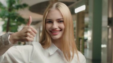 Happy woman 20s businesswoman girl showing thumb up approve gesture yes recommend good business idea agree support excellent result achieve agreement positive lady posing with raised finger in office