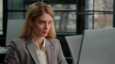 Caucasian middle-aged 40s woman sit in office use laptop check email in computer read good news offer sale price career promotion salary growth. Adult businesswoman winner celebrate online win victory