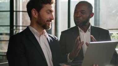 Diverse men partners multiracial colleagues Caucasian man insurance agent consultant adviser and African American investor client with laptop happy satisfied talking online success business in office
