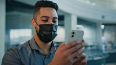 Arap Hindistanlı etnik işadamı hasta ruhlu girişimci elinde cep telefonu ile geziyor akıllı telefon işi yapıyor ofiste cep telefonuyla sohbet ediyor.