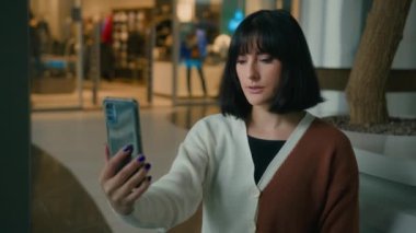 Beyaz kadın, akıllı telefonlu internet kamerasıyla konuşuyor. Ciddi iş kadını, alışveriş merkezindeki bir kadın cep telefonu konferansında görüntülü görüşme yapıyor.