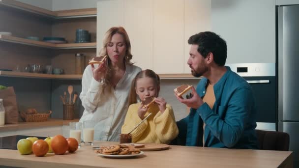 快乐的白人家庭一起在厨房吃早餐 快乐的父母和可爱的小女孩一起在家里吃饭 一起吃面包和巧克力三明治 爸爸和女儿一起吃饭 — 图库视频影像