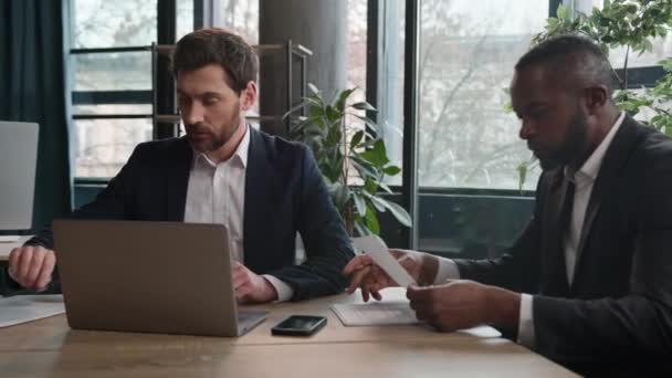 不同的职业商人白种人商人和非裔美国商人多种族伙伴男人持证件和手提电脑在办公室交谈在商务会议上讨论在线项目 — 图库视频影像