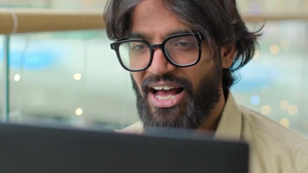 ノートパソコンでのメガネビデオ通話で男髭の幹部を閉じます インドのビジネスマンアラビア語男は 顧客のウェブカメラチャットを距離に話す会議コールビジネスエージェントマネージャーを交渉ウェブトーク — ストック動画
