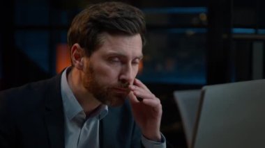 Caucasian exhausted businessman 40s middle aged man overwork with late night computer work in evening office sick ill tired worker manager feel fatigue stress headache has business problem crash fail