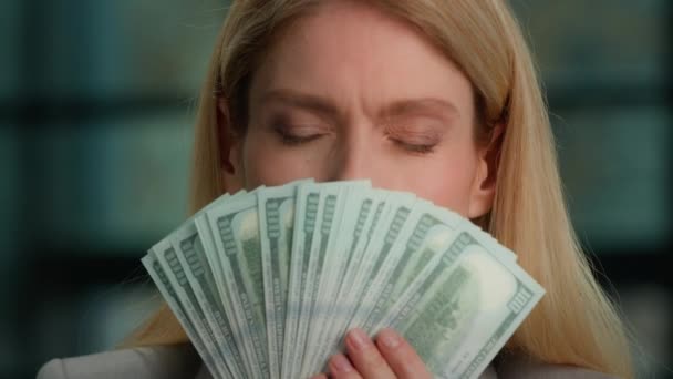 近视白种人40多岁的女性中年妇女富有的成功的商界女性拥戴金钱的女性嗅闻美元的气味对金融收入的增长感到满意的钞票钞票 — 图库视频影像