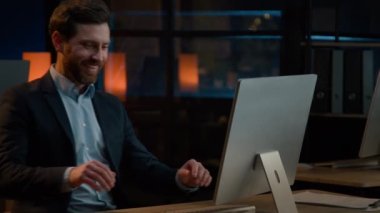 Night late job in company Caucasian businessman middle-aged adult man have fun riding seated on office chair start working with computer at desk professional worker male employee typing on pc keyboard
