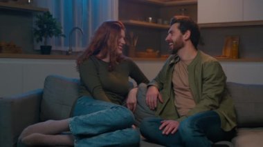 Mutlu, genç, beyaz aile sohbetleri kanepede oturup ev erkeği ve kadın arasında dinlenirken gülüşmeler, hoş sohbetler, evlilik ilişkileri kavramları.