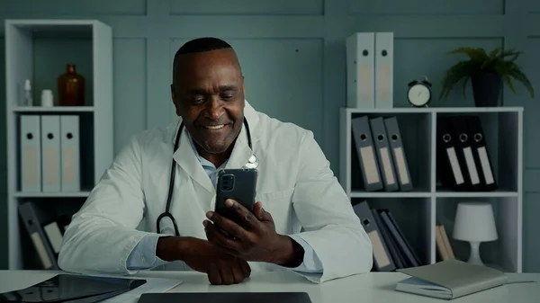 Afrikanischer Arzt Mann Mittleren Alters Arbeiter Verwenden Handy Gadget Sms — Stockfoto