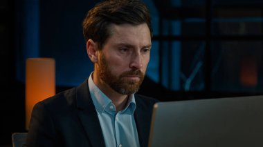 Close-up male business portrait confident focused businessman millennial caucasian senior 40s adult bearded man chief boss leader thinking online project work with computer in evening office indoors