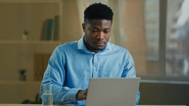 Businessman african american man working on computer in home office make pause drinking glass of cold fresh water health habit hydrate body mineral pure aqua drink recreation weight healthy metabolism