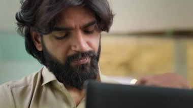 Exhausted Indian bearded businessman taking off glasses feel headache eye strain discomfort. Overworked Arabian man worker feeling fatigue after office work with laptop business stress problem failure