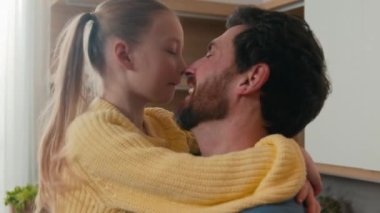 Little adopted daughter child kid girl and bearded man father dad touch noses fooling enjoy bonding carefree time together at home kitchen hugging cuddling. Caucasian family bond love happy fatherhood