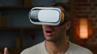 African american latino man gamer in VR goggles play game use virtual reality augmented glasses watching real simulation gaming modern 3d metaverse technology amazed ethnic millennial playing indoors