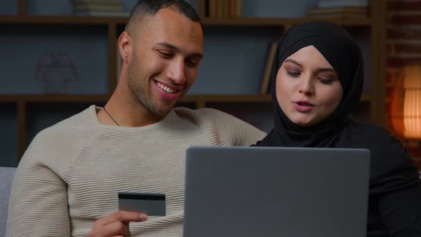 Σύζυγοι Εθνοτήτων Χρησιμοποιούν Πιστωτική Κάρτα Φορητό Υπολογιστή Αφροαμερικανός Άνδρας Μουσουλμάνος — Αρχείο Βίντεο