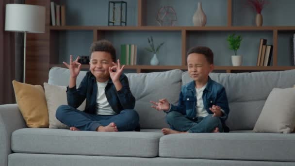 Два Маленьких Афроамериканских Мальчика Сидят Диване Гостиной Позе Лотоса Медитируют — стоковое видео