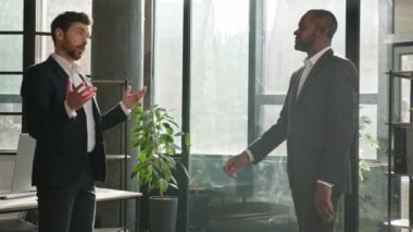 Şirket temsilcisi çeşitli erkek ortaklar ofis toplantısına geliyor. Beyaz iş adamı el sıkışıyor. Afro-Amerikan arabulucu saygıdan bahsediyor.