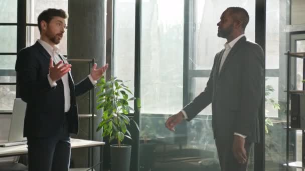 会社の代表握手多様な男性パートナー会議室に来る白人ビジネスマン握手歓迎アフリカ系アメリカ人交渉人男握手を尊重話します — ストック動画