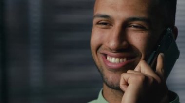 Kapalı kapılar ardında gülümseyen Afrikalı Amerikalı bir adam cep telefonuna cevap veriyor. Akıllı telefondan arkadaşça konuşun. Mutlu etnik erkek işadamı, uzaktan konuşmanın tadını çıkarın.