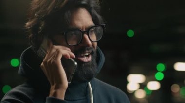 Otoparkta gözlüklü, sakallı, Hintli, gülümseyen, gözlüklü, gözlüklü, yetişkin, iş adamı, telefon görüşmeleri.