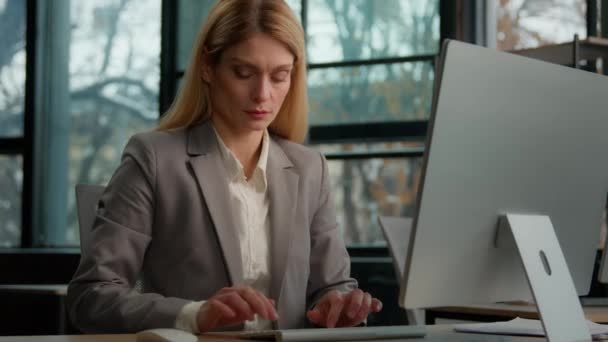 白领40多岁的白领40多岁的女商人在办公室里打字疲倦困倦的坐在写字台前疲惫不堪的中年妇女工作过度劳累的女工行政人员对网上工作感到厌倦 — 图库视频影像