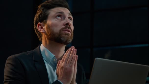 사업가가 어두운 사무실에서 컴퓨터 기도를 축복을 달라고 기도한다 — 비디오
