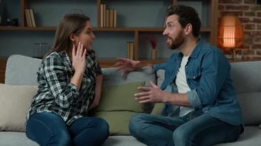 Beyaz tenli çift, aile dostu, kardeş, kız kardeş, kadın ve erkek rahat koltukta oturup planlar hakkında konuşuyorlar.