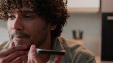 Hintli adam elinde akıllı telefon tutarken hoparlörle arkadaşınla konuşuyor cep telefonu hoparlörüyle konuşuyor. Arap bir işadamı mutfakta sesli mesaj kaydediyor.