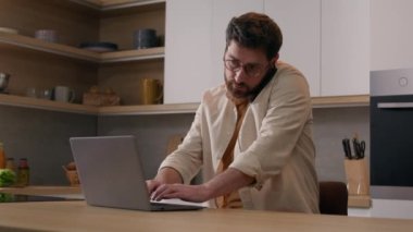Ev telefonuyla konuşan, birden fazla işi olan beyaz tenli bir adam karantinada serbest çalışan bir iş adamı. Erkek müşteri mutfakta bilgisayar uygulaması ve akıllı telefonla yemek siparişi veriyor.