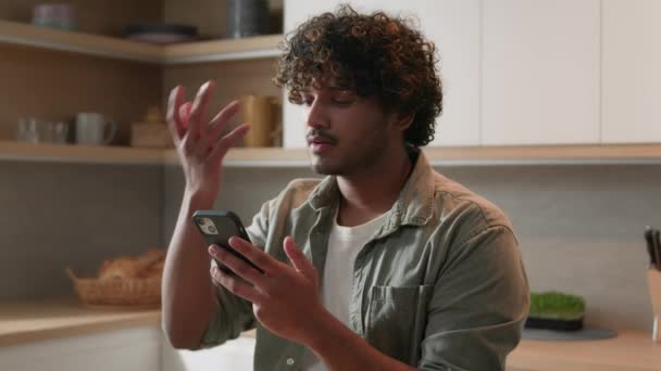 Indiase Etniciteit Man Zitten Aan Keukentafel Thuis Met Smart Phone — Stockvideo