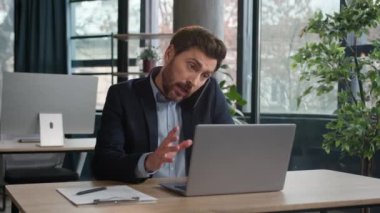 Kafkasyalı çoklu görev sahibi iş adamı dizüstü bilgisayarla telefonla konuşuyor satış temsilcisi, profesyonel yönetici danışman müşteri cep telefonu kullanıyor iş yerindeki uzaktan tartışma anlaşmasını açıklıyor
