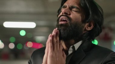 Frustrated stressed young indian man suffering due to life grief feel despair unhappy due personal troubles divorce debt financial problems worried arabian businessman feeling crisis praying with hope