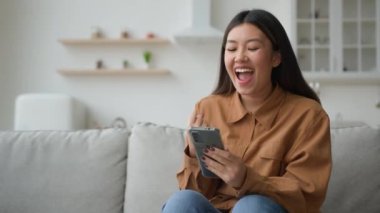 Akıllı telefon sahibi Asyalı kadın uygulamadan bedava ödül kazanıyor. Heyecanlı Koreli Çinli iş kadını. Piyango parasını kullanıyor. Mobil zafer kazanıyor.