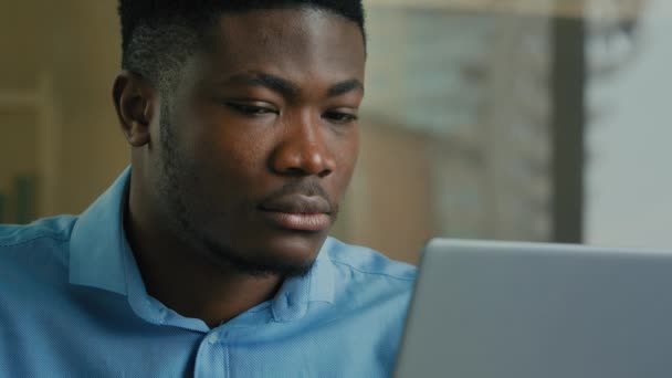 集中的なビジネスマンアフリカ系アメリカ人の民族の男性エグゼクティブワーカーは 自宅のオフィスで働くノートパソコンの画面を見てメールを入力男性起業家は インターネット上でオンライン検索情報を使用します — ストック動画