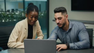 Afrikalı Amerikalı kadın lider akıl hocası iş kadını erkek stajyer Hintli Arap erkek işadamına şirket laptopuyla alkış tutarak alkışlamalarında yardımcı oluyor.