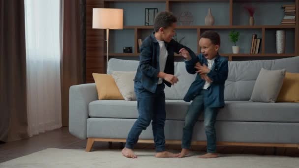 两个顽皮的小男孩在家里打哈欠 嬉笑着大声笑着 非洲裔美国兄弟姐妹兄弟族裔孩子玩打打斗游戏嬉闹着在客厅里玩耍Adhd — 图库视频影像