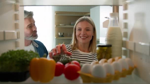 중년의 부부와 아내는 냉장고를 토마토 양배추 우유를 꺼내서 냉장고 안에서 — 비디오