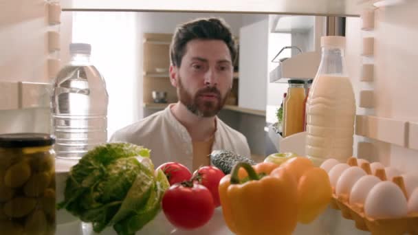 观点冰箱里的Pov饥饿的白种人男厨师打开冰箱健康的蔬菜选择吃苹果在家里吃厨房里的水果送餐健康饮食 — 图库视频影像