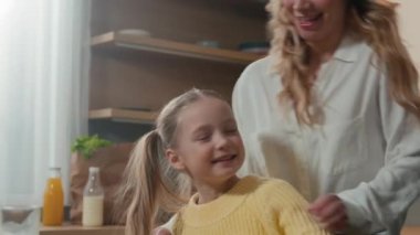 Neşeli bir aile annesi ve küçük bir kız çocuğu mutfakta oynaşırken eğleniyorlar. Mutlu anne gıdıklıyor tatlı kız oyun oynuyor gıdıklıyor saklambaç oynuyor ve sarılıyor birlikte gülüyor