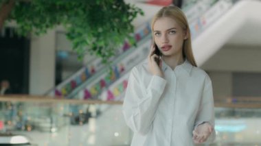 Alışveriş merkezinde cep telefonuyla konuşan iş kadını beyaz kadın girişimci kadın cep telefonuyla konuşuyor. Müşterilerle internet üzerinden iletişim kuruyor. Ofisteki akıllı telefon konuşmalarıyla.