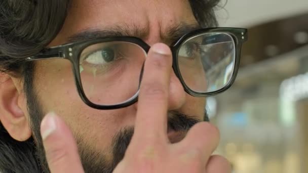 眼鏡で極端なクローズアップ男性の目距離を見て正しい眼鏡を調整するインドの集中的な思考の男は 問題の解決策を熟考考えるビジネスマン思慮深い視力悪いビジョン — ストック動画