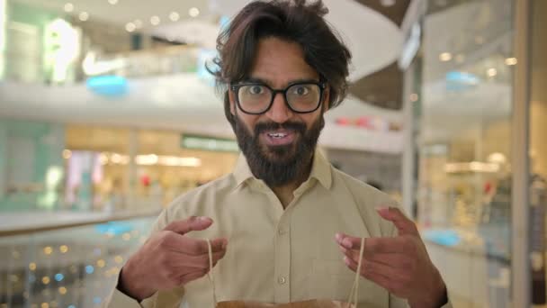 インドの興奮した幸せな驚き陽気な男買い手顧客ビジネスマンアラビア語ひげ男で眼鏡オープンパッケージショッピングバッグ見て内側に喜び現在の贈り物不思議感情でモール — ストック動画
