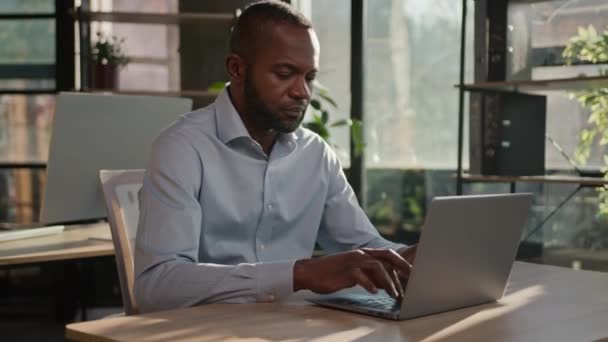 アフリカ系アメリカ人成熟した大人の民族中年男性専門ビジネスマンオフィスのシニアマネージャー従業員集中型ラップトップ検索ウェブサイトインターネットデータオンラインビジネスワーク — ストック動画