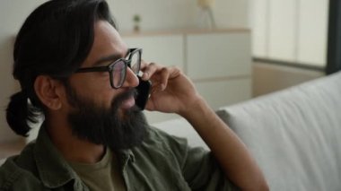 Arap Müslüman erkek serbest çalışan, evde cep telefonuyla konuşan, gülümseyen, Hintli sakallı, iş adamı, cep telefonuyla konuşan kaygısız, sohbet eden, cep telefonu görüşmeleri yapan bir iş adamı.