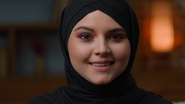 肖像画黒の伝統的なヒジャーブのアラビア語のイスラム教徒の女性のカメラを見て幸せな歯の笑顔微笑んだ 閉じるアップ女性の顔イスラムトルコ語の女の子は 頭のスカーフの頭を着用中東の美しさを撮影 — ストック動画