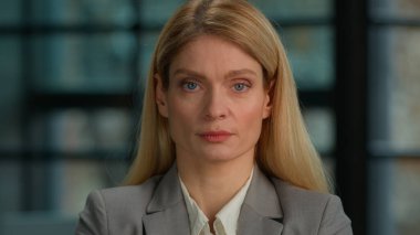 Kendine güvenen, başarılı, orta yaşlı, ciddi, sakin, profesyonel bir iş kadınının portresi. Yetişkin kadın yönetici yönetici iş sahibi bayan işveren kameraya bakıyor.