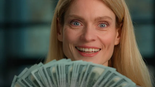 Close up satisfied rich 40s woman happy with financial cash winning victory prize. Head shot Caucasian woman middle-aged adult businesswoman holding fan counting money dollars finance salary banknotes